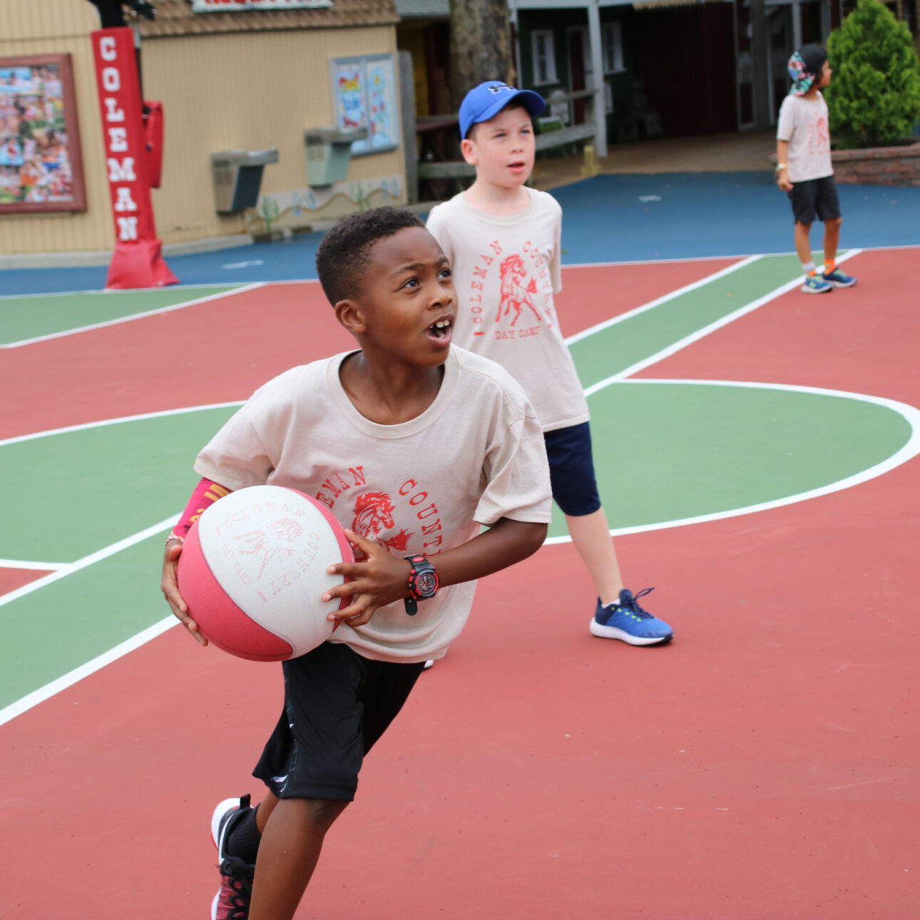Boy camper running with a basketball during a game
