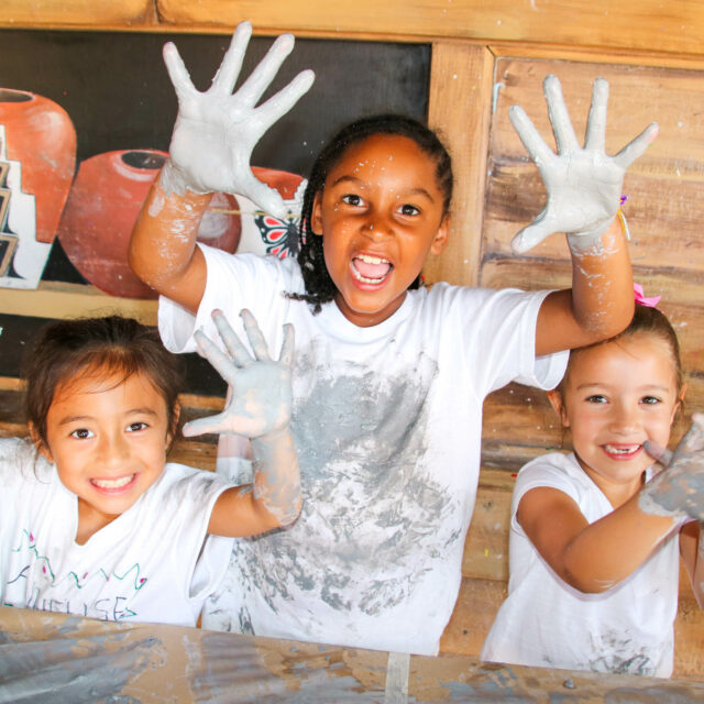 Campers with messy hands doing arts and crafts.