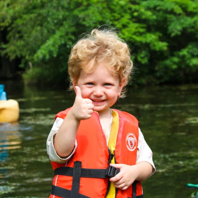 Pioneer camper giving a thumbs up on the lake.