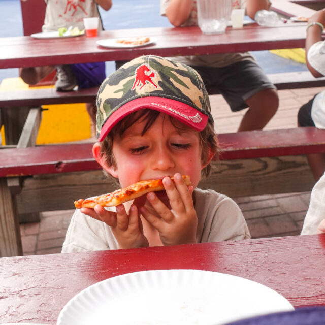 Pioneer camper eating pizza.