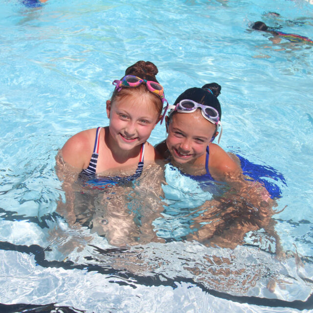 Two girl campers in the pool together