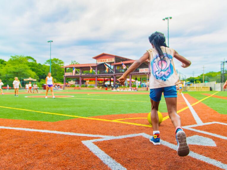 Girl runs up to kick ball across field