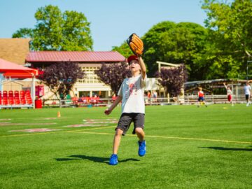 Camper runs backward to catch baseball