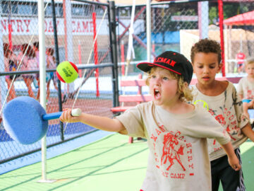Young campers practicing tennis skills.