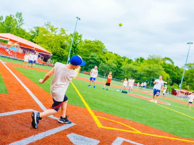 Boy kicking a ball at a kickball game.