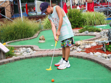 Camper playing mini golf.