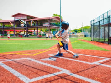 Camper hitting a baseball at a game.