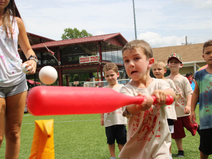 Young camper playing t-ball.