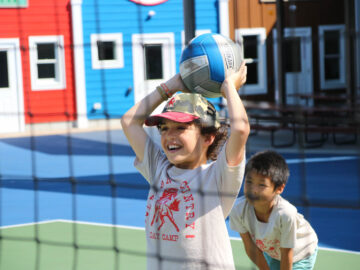 Campers playing volleyball outside.