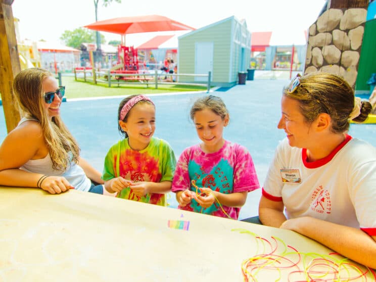 Campers and counselors make friendship bracelets