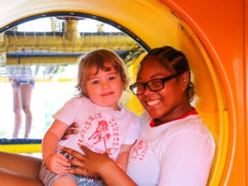 Counselor with a young PIT camper on the playground.