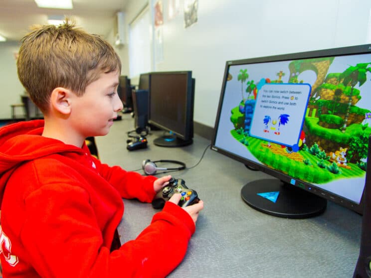 Boy plays Sonic on computer at camp