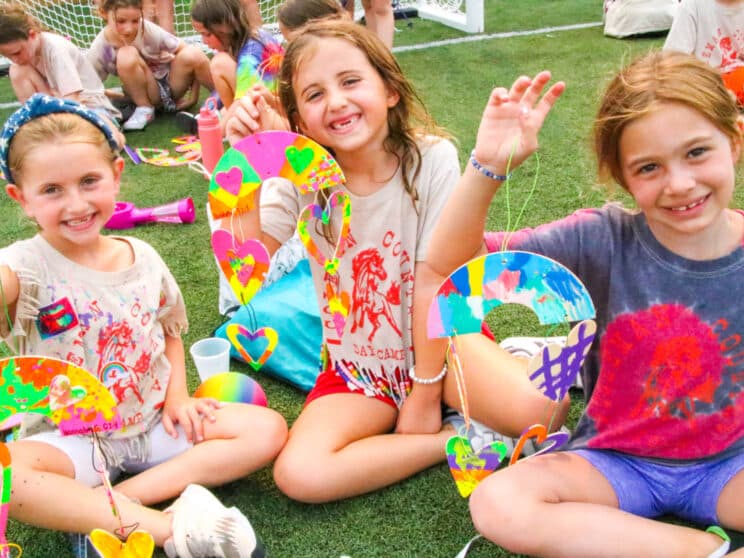 Three campers with their arts and crafts creations.