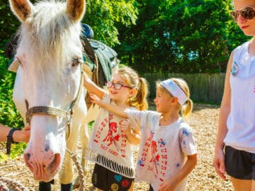 Two campers petting a horse.