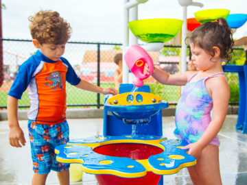 Two young campers play in the splash zone