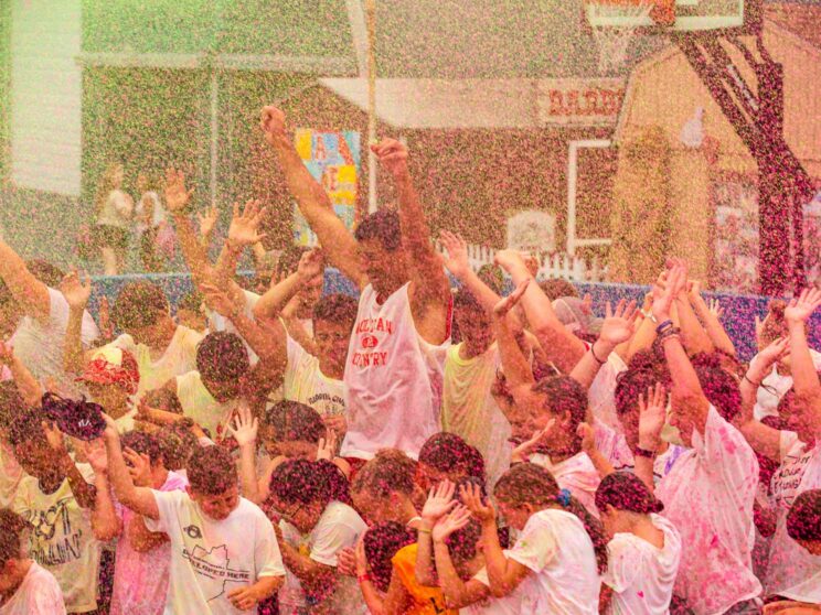 Large group cheers during color run spray