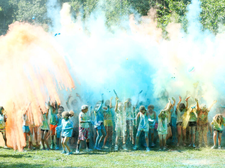 Campers throwing color chalk from the run into the air