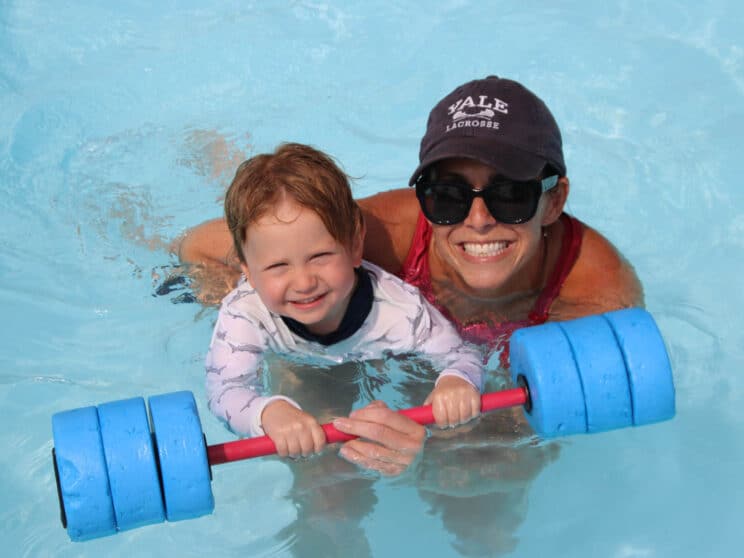 Counselor teaching a camper to swim.