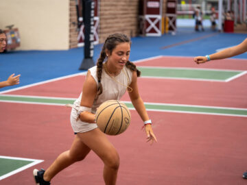 Girl running with a basketball.
