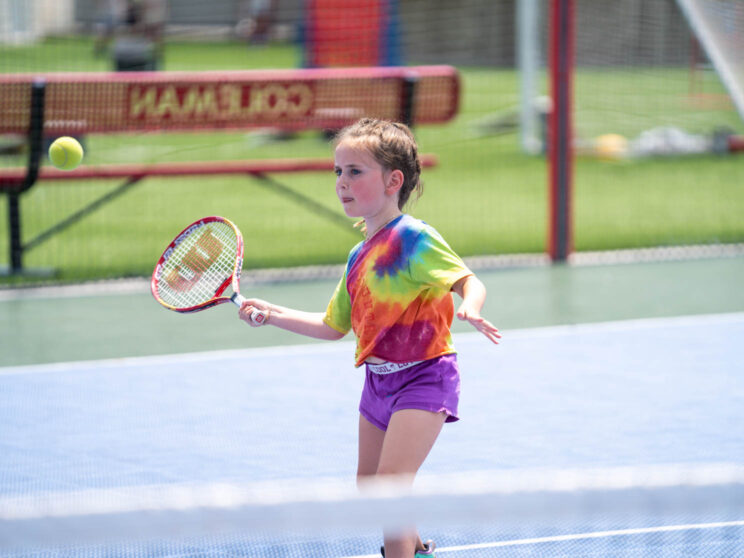 Girl about to hit a tennis ball.