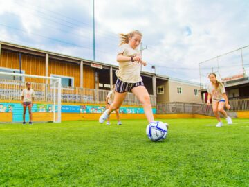 Girl kicks soccer ball at camp