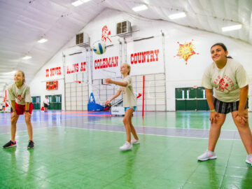 Girls playing indoor volleyball.