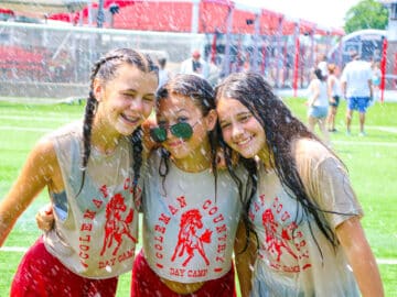 Girls soaking wet on field.