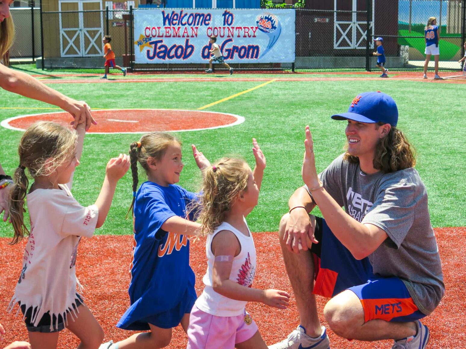 Jacob deGrom high fives a row of campers