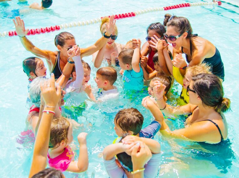 Group of young campers cheer in pool