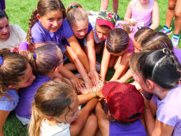 Group of campers all in purple in a huddle.