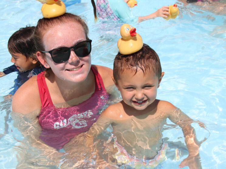 Counselor and camper with rubber ducks on their heads.