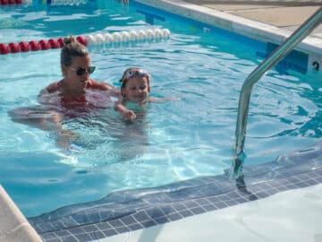 Counselor teaching a camper to swim.