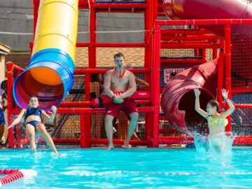 Two campers exit water slides into pool