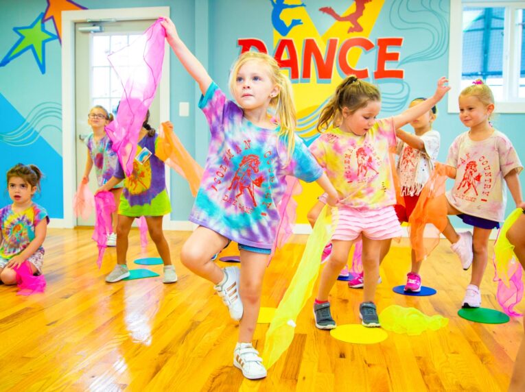 Young girl poses in front of camper dance practice