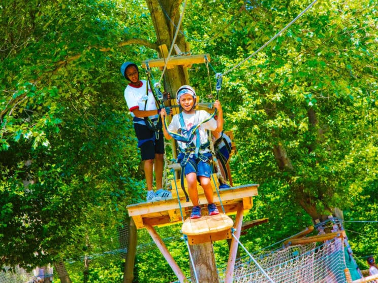 Camper stands on platform to zipline.