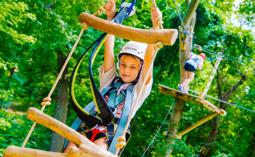 Camper climbs ladder on challenge course