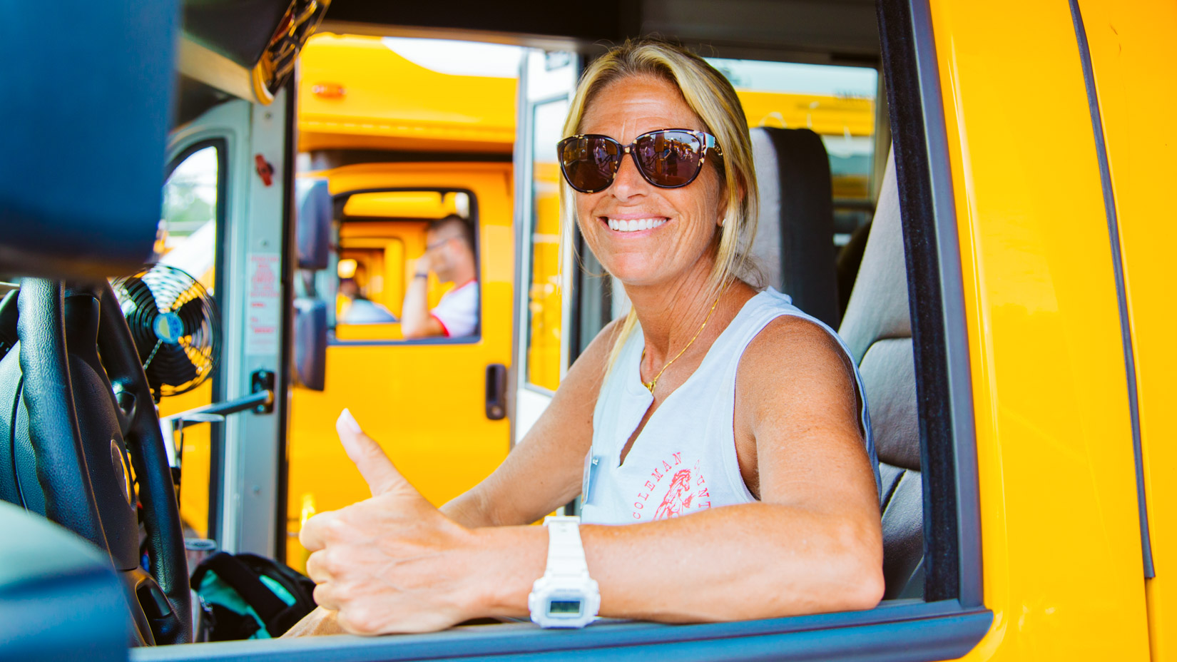 Camp bus driver gives thumbs up through window