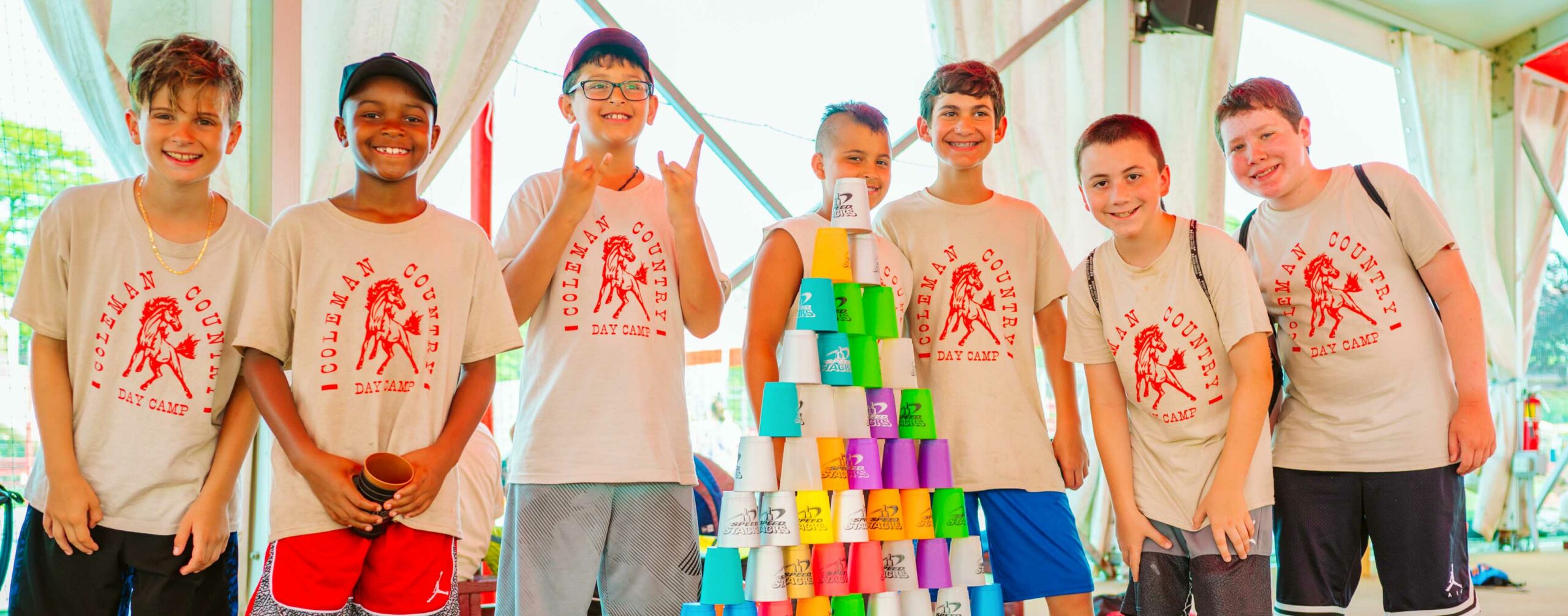 Group of Coleman Country campers stand behind cup stack