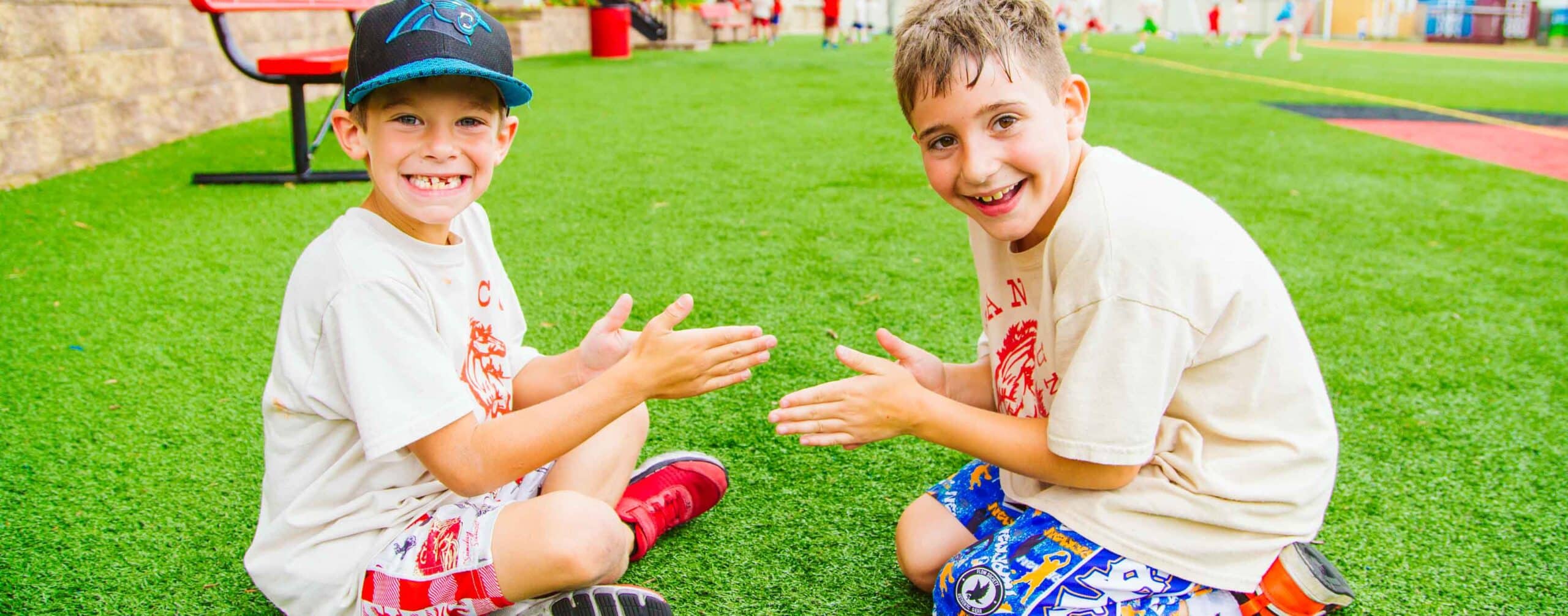 Two young campers play a hand game