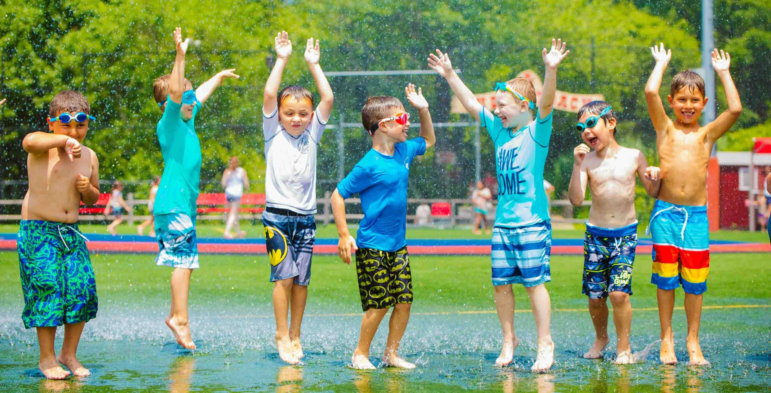 Campers jump around in water spray