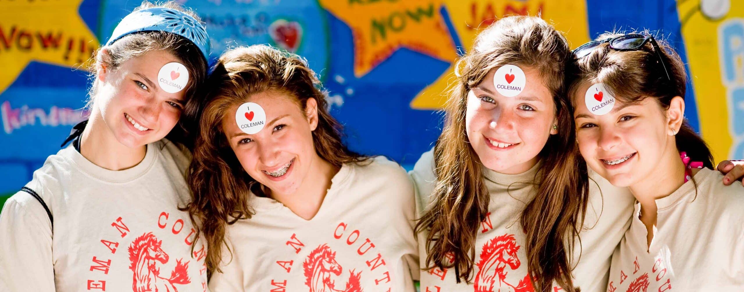 Smiling campers with "I ❤️Coleman" stickers on foreheads