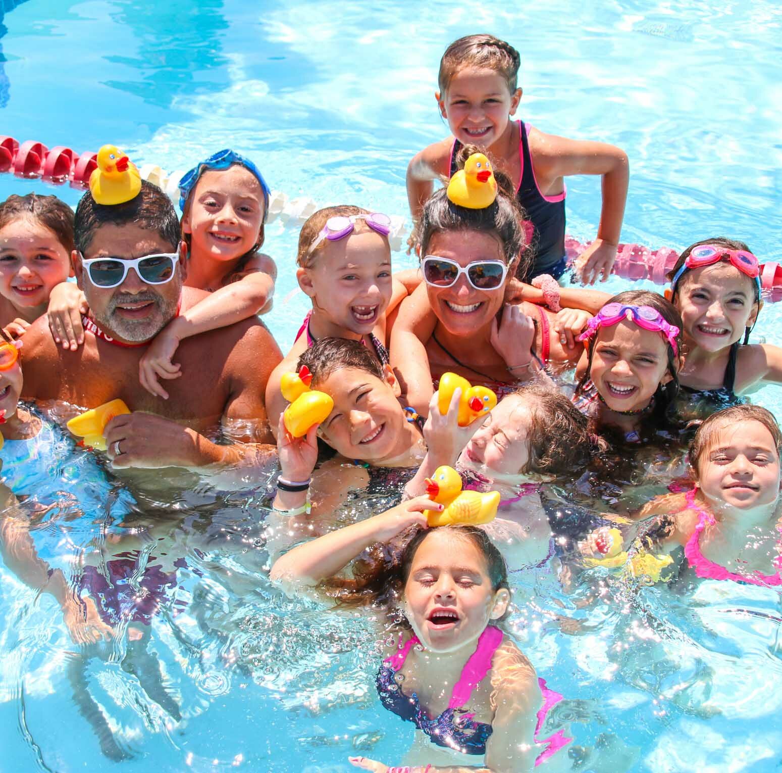 Counselors and campers with rubber ducks in the pool