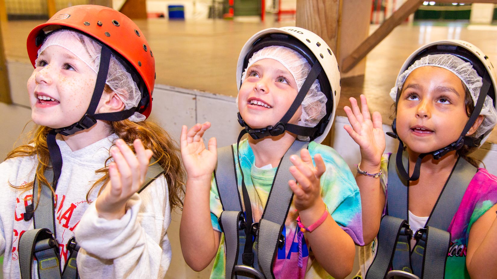 Young campers look up while waiting to rock climb