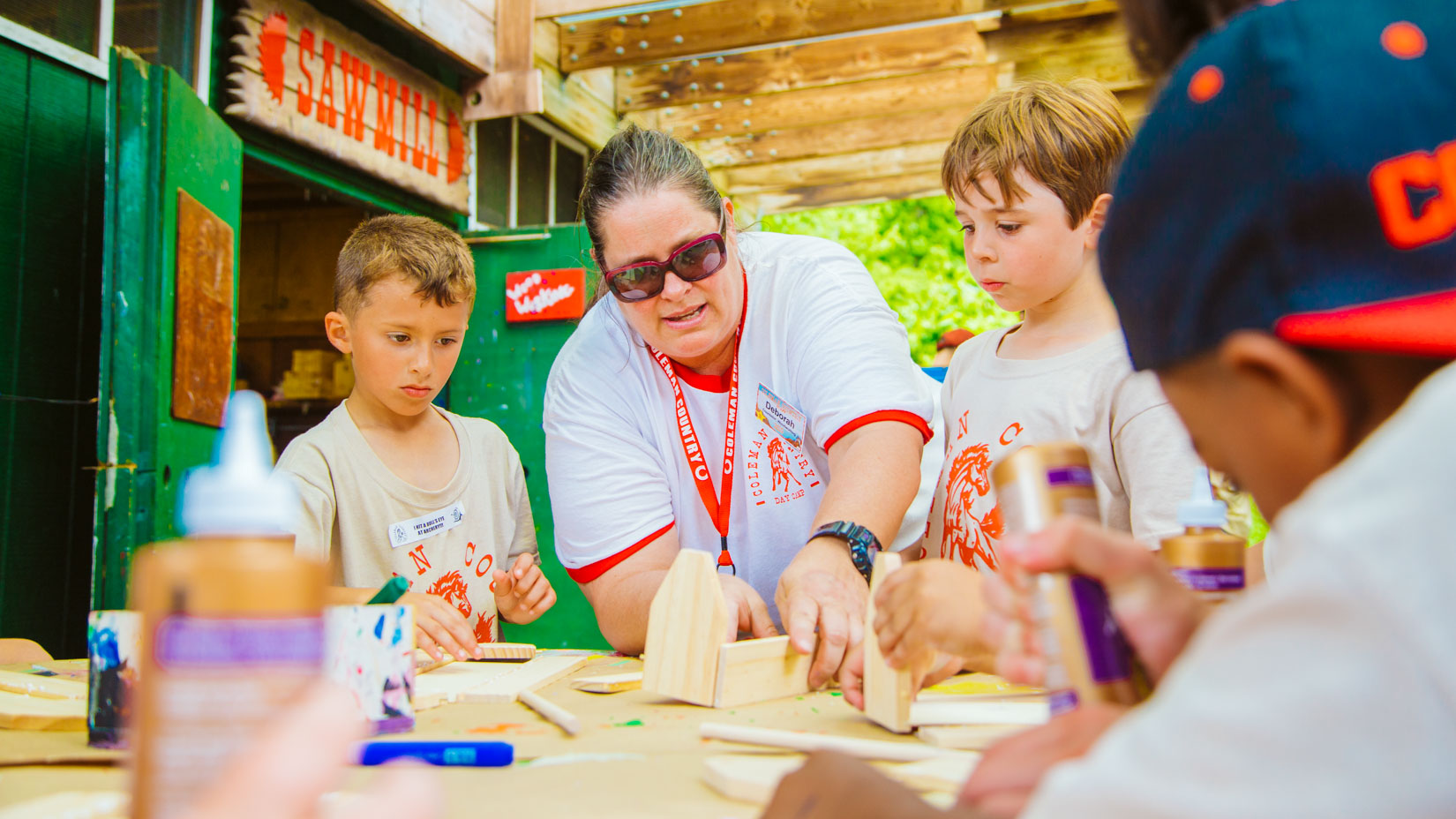 Woodworking counselor helps campers with projects