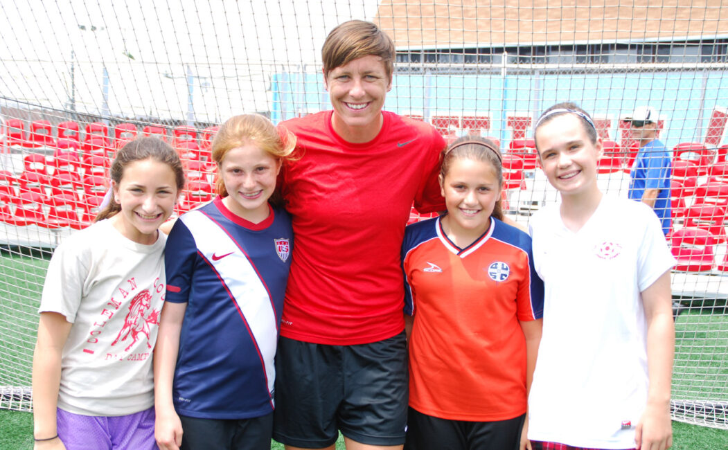 Abby Wambach group photo with girls in front of soccer net