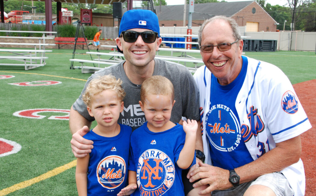 David Wright group photo with two young campers and a counselor on the baseball field