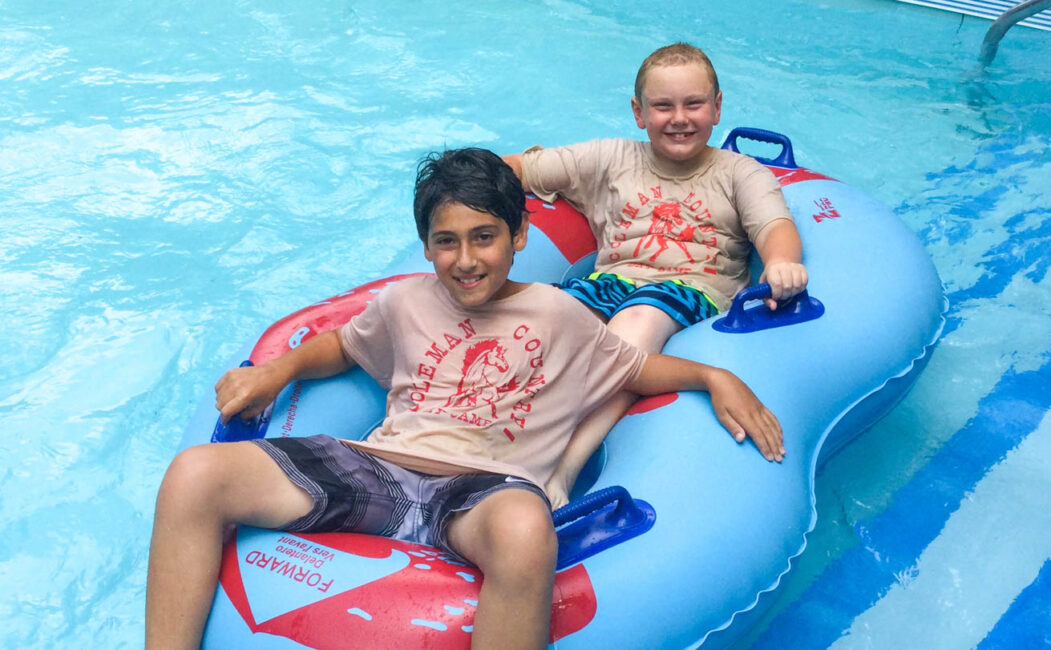 Two campers in an inner tube at a water park.