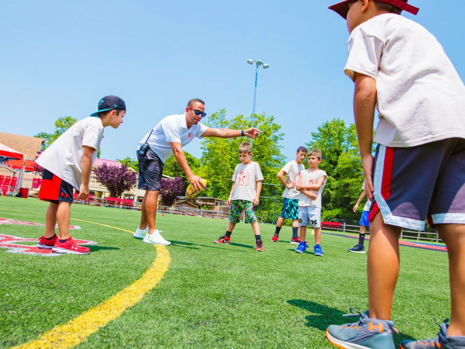 Football instructor teaching campers how to play football