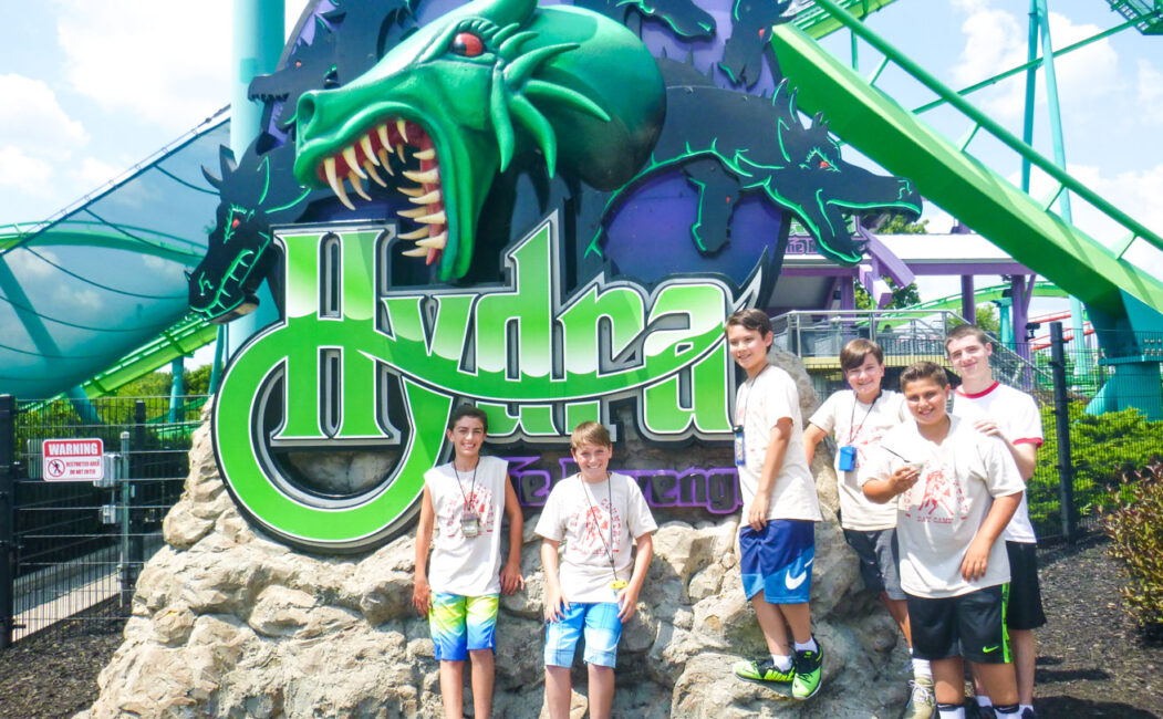 A few boy campers in front of the Hydra roller coaster sign