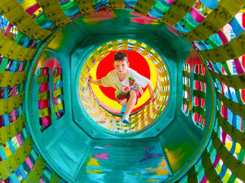 Camper in a play structure tunnel.